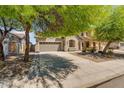 Inviting two-story home with a manicured front yard, mature trees, and a spacious three-car garage at 35709 N Zachary Rd, San Tan Valley, AZ 85144