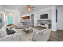 Bright living room featuring modern decor, hardwood floors, and an open floor plan leading to the kitchen at 35709 N Zachary Rd, San Tan Valley, AZ 85144