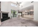 Spacious living room with high ceilings, fireplace, wet bar and sliding door access to the patio at 3740 E Tonto Ct, Phoenix, AZ 85044