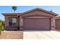 Single story house with desert landscaping with 2 car garage and a palm tree in the front yard at 43711 W Elm Dr, Maricopa, AZ 85138