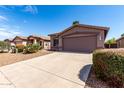Single story house with desert landscaping and a 2 car garage on a sunny day at 43711 W Elm Dr, Maricopa, AZ 85138