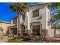 Two-story home with desert landscaping and a palm tree in front at 45247 W Jack Rabbit Trl, Maricopa, AZ 85139
