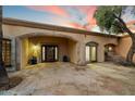 Covered entrance with stone details, custom iron door, and desert landscaping at 4744 E Foothill Dr, Paradise Valley, AZ 85253