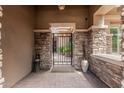 Elegant courtyard entryway with custom stone work, potted plants, and decorative iron gate at 5291 S Bradshaw Pl, Chandler, AZ 85249
