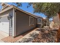 Charming single-story home with a gray exterior, a two-car garage, with dark colored trim at 6320 W Mercer Ln, Glendale, AZ 85304