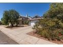 Charming single-story home with a gray exterior, a two-car garage, basketball hoop, and a well-manicured yard at 6320 W Mercer Ln, Glendale, AZ 85304