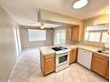 Galley kitchen featuring tile floors, natural wood cabinets, and bright natural light at 814 S 80Th St, Mesa, AZ 85208