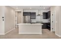 Modern kitchen with a white island, stainless steel appliances, and dark cabinetry at 10974 W Taylor St, Avondale, AZ 85323