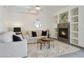 Inviting living room with a cozy fireplace, built-in shelving, and neutral decor at 11832 E Clinton St, Scottsdale, AZ 85259