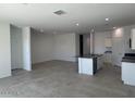 Bright open-concept living area with tile floors and a kitchen island at 1360 W Hess Ave, Coolidge, AZ 85128
