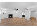 Light-filled living room with a sleek fan, hardwood floors, and a fireplace at 1658 N Old Colony Dr, Mesa, AZ 85201