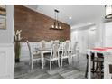 Dining area showcases a wood accent wall, modern light fixture, and elegant seating for eight at 2025 N 87Th Way, Scottsdale, AZ 85257