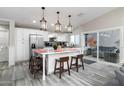 Bright kitchen boasts stainless steel appliances, marble island, and glass doors to the backyard lounge area at 2025 N 87Th Way, Scottsdale, AZ 85257