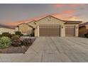 Inviting home featuring a well-maintained front yard, three-car garage, and clay tile roof at 20359 N 262Nd Dr, Buckeye, AZ 85396