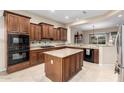 Spacious kitchen featuring granite countertops, an island, and dark wood cabinetry at 20359 N 262Nd Dr, Buckeye, AZ 85396