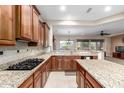 Open-concept kitchen featuring granite countertops, a gas range, and dark wood cabinets at 20359 N 262Nd Dr, Buckeye, AZ 85396