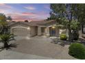 Single-story home with a two-car garage, desert landscaping, small front porch and mature trees at 21192 E Stirrup St, Queen Creek, AZ 85142