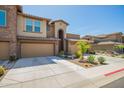 Charming home exterior with a two-car garage, desert landscaping, and decorative stone accents at 2425 W Bronco Butte Trl # 2028, Phoenix, AZ 85085