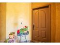 Close-up of the front door with potted flowers on a side table, creating a welcoming entrance at 2425 W Bronco Butte Trl # 2028, Phoenix, AZ 85085