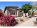 Charming home exterior with desert landscaping, including colorful bougainvillea and a view of the tile roof at 2610 W Sat Nam Way, Phoenix, AZ 85086