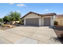 Well-maintained single-story home with neutral exterior, tile roof and large concrete driveway at 27291 W Mohawk Ln, Buckeye, AZ 85396