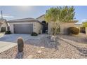 Front exterior of home with desert landscaping, mature shade tree and two car garage at 2930 N 154Th Dr, Goodyear, AZ 85395