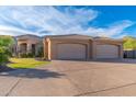 Spacious three-car garage with an expansive driveway and manicured lawn at 3042 W Windsong Dr, Phoenix, AZ 85045