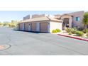 Exterior view of garage, with multiple bays, and a building with stairs and desert landscaping at 34457 N Legend Trail Pkwy # 1013, Scottsdale, AZ 85262