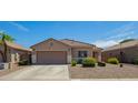 Inviting single-story home boasts a well-maintained desert landscape and two-car garage at 34463 N Karan Swiss Cir, San Tan Valley, AZ 85143