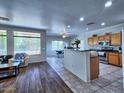 Open-concept kitchen with modern appliances and an island overlooking the dining area at 44182 W Juniper Ave, Maricopa, AZ 85138