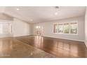 Empty living room featuring hard floors, white walls, French doors and bright natural lighting through shuttered windows at 4940 S Rosemary Dr, Chandler, AZ 85248