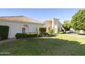 Landscaped front yard featuring a well-maintained lawn and lush greenery, with a charming single-story home in the background at 541 E Spur Ave, Gilbert, AZ 85296