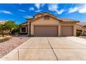 Charming home featuring a three-car garage, desert landscaping, and a tile roof at 7261 E June St, Mesa, AZ 85207