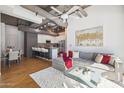 Open concept living room with modern kitchen, exposed ductwork, and a cozy gray couch at 1 E Lexington Ave # 302, Phoenix, AZ 85012