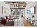Living room featuring exposed ductwork, large windows, and a comfortable gray couch at 1 E Lexington Ave # 302, Phoenix, AZ 85012