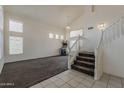 Inviting living room with staircase, featuring carpet flooring and natural light, showcasing a spacious design at 1079 E Jasper Dr, Gilbert, AZ 85296