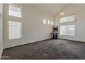 Bright and spacious living room with high ceilings and large windows, featuring neutral-toned carpet at 1079 E Jasper Dr, Gilbert, AZ 85296
