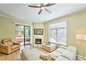 Bright living room with fireplace, wood floors, and sliding glass doors that lead to an outdoor patio at 11640 N Tatum Blvd # 1095, Phoenix, AZ 85028