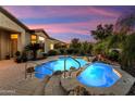 Beautiful backyard pool and spa area with rock waterfall feature and lush desert landscaping at 12976 W Plum Rd, Peoria, AZ 85383