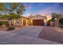Home exterior with brick-lined driveway and manicured lawn with illuminated landscaping at 16229 W Berkeley Rd, Goodyear, AZ 85395