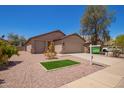 Well-maintained single-story home with desert landscaping, grassy area and attached two-car garage at 16274 N 138Th Ln, Surprise, AZ 85374