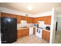 Functional kitchen with wooden cabinets, white appliances and a neutral color palette at 1905 E Inverness Ave, Mesa, AZ 85204