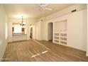 Open-concept living area with new laminate floors, custom built-ins, and arched doorways to the dining area at 2667 S 156Th Ave, Goodyear, AZ 85338