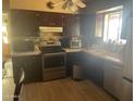 Traditional kitchen featuring dark wood cabinetry, stainless steel appliances, tile backsplash, and tile countertops at 277 W 16Th Ave, Apache Junction, AZ 85120