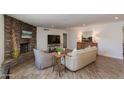 Open living room features a stone fireplace, wood floors and neutral furnishings at 3020 E Mission Ln, Phoenix, AZ 85028