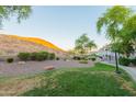 Green common area with sidewalk surrounded by desert landscaping with mountain backdrop at 3236 E Chandler Blvd # 3031, Phoenix, AZ 85048