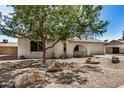 Exterior view of the home features desert landscaping, natural shade and a front porch at 4121 W Paradise Dr, Phoenix, AZ 85029