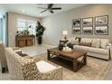 This is a spacious living room with neutral walls, a ceiling fan, and comfortable seating at 4215 W Suncup Dr, San Tan Valley, AZ 85144