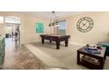 The game room features a pool table, neutral walls, and views into other living spaces at 44041 W Bailey Dr, Maricopa, AZ 85138