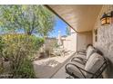 Relaxing covered back patio with ample seating, landscaping, and desert sunlight at 4531 W Continental Dr, Glendale, AZ 85308